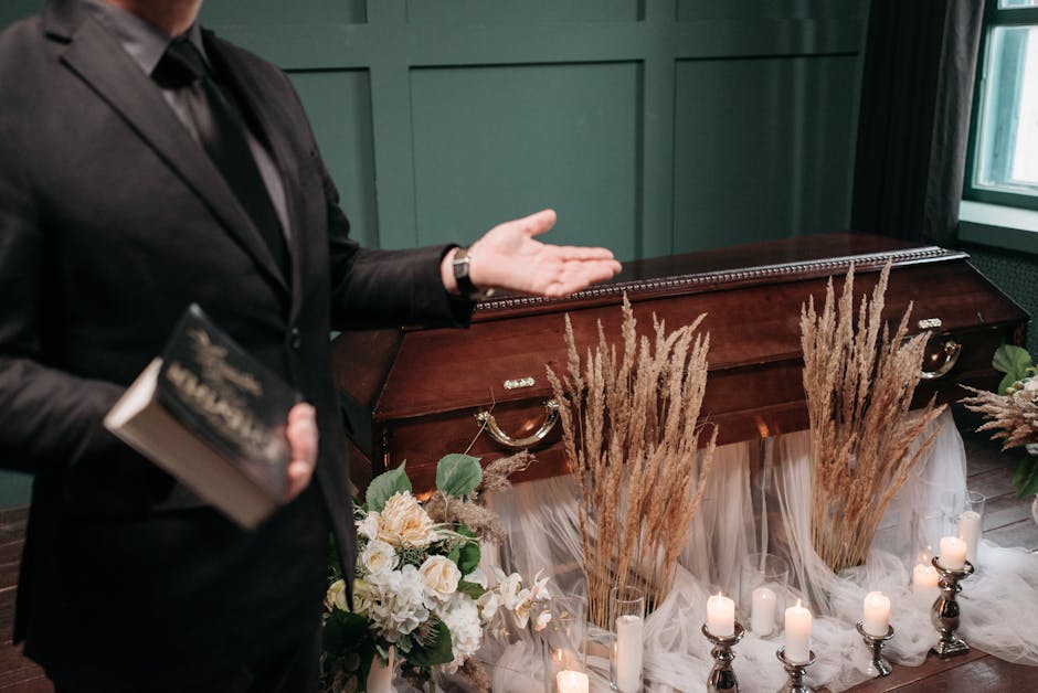 A respectful funeral setting with a closed coffin, flowers, and a man holding a book.