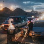 A man waiting by lines of cars going through a checkpoint from Ramallah, Palestine to enter Israel.