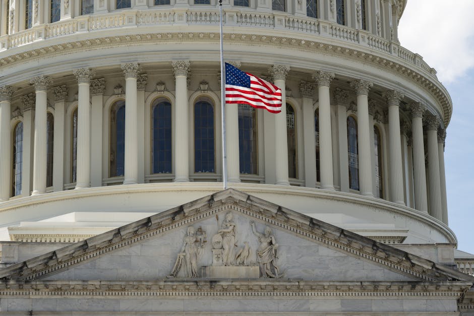 Close-up of the Capitol building in Washington DC with the US flag waving in front.