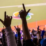 A crowd of people raising their hands in the air