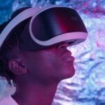 Close-up of a person wearing VR glasses in a neon-lit environment, showcasing technology and user experience.
