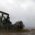 an oil pump sitting on top of a dirt field