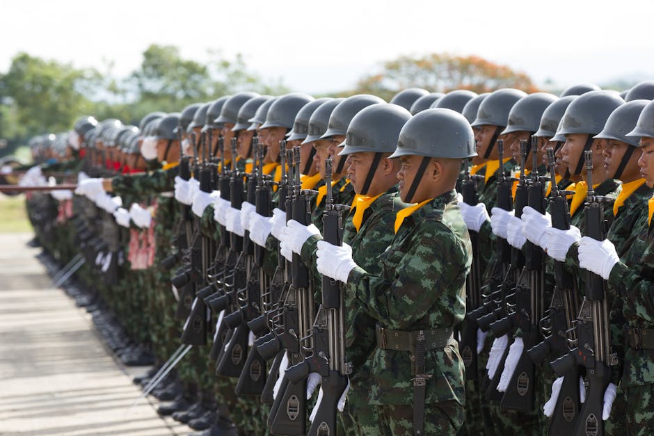 Soldiers in uniform march in a disciplined formation during a military parade outdoors.