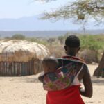 a woman carrying a child on her back