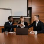 Diverse business team having a successful meeting and agreement, shaking hands across the table.