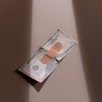 A $50 bill with a bandage symbolizes financial recovery and repair.