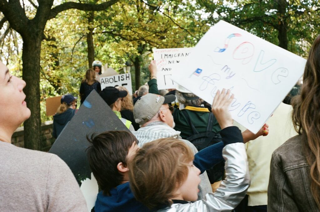 People holding signs at an outdoor rally