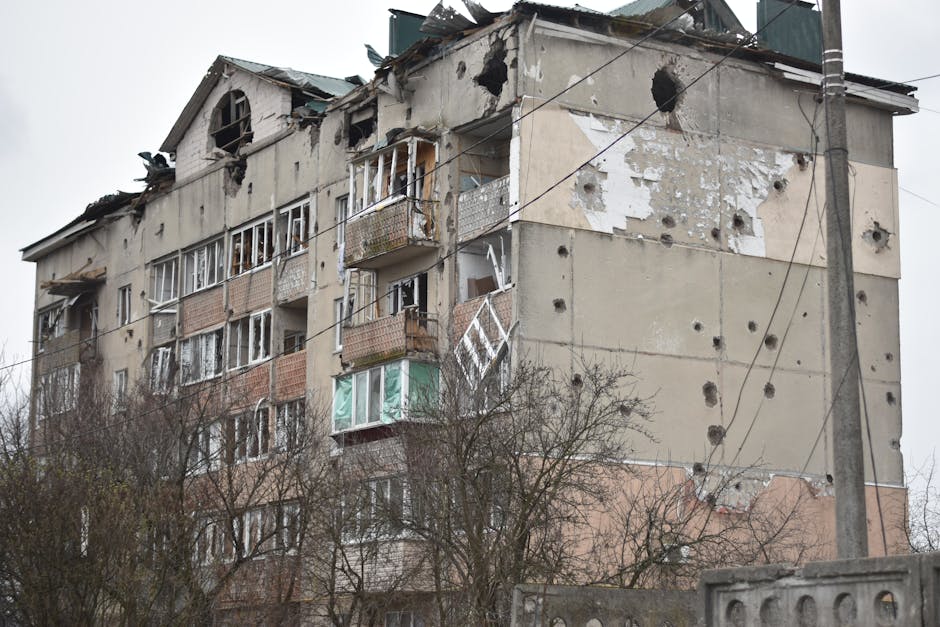 A damaged apartment building showing extensive artillery damage and decay.