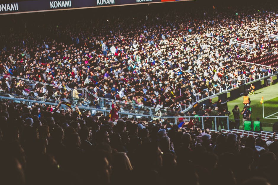 A crowded soccer stadium packed with enthusiastic fans during a match.