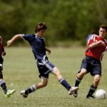 Teenage soccer players in action during an outdoor match showcasing skill and competition.