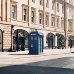 Charming city street scene featuring a distinctive blue police box amidst urban architecture.