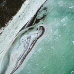 A breathtaking aerial view of a tranquil beach in Yucatan, Mexico with azure waters and white sand.