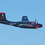Vintage B-26 Invader aircraft in flight under clear skies, showcasing military aviation history.