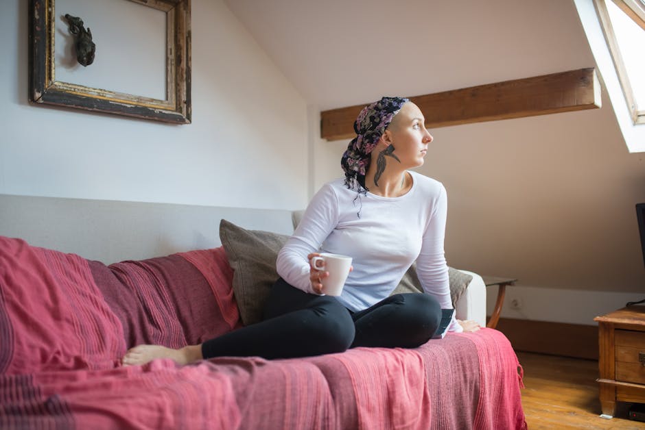 Serene woman in headscarf relaxes on sofa while holding mug, bathed in soft daylight.