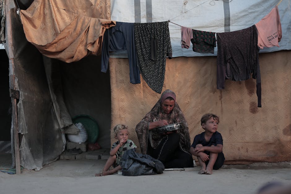 A family outside a tent in a Gaza refugee camp, highlighting daily life and resilience.
