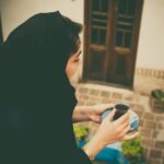 An Iranian woman savoring tea in a traditional courtyard in Kashan, Iran.