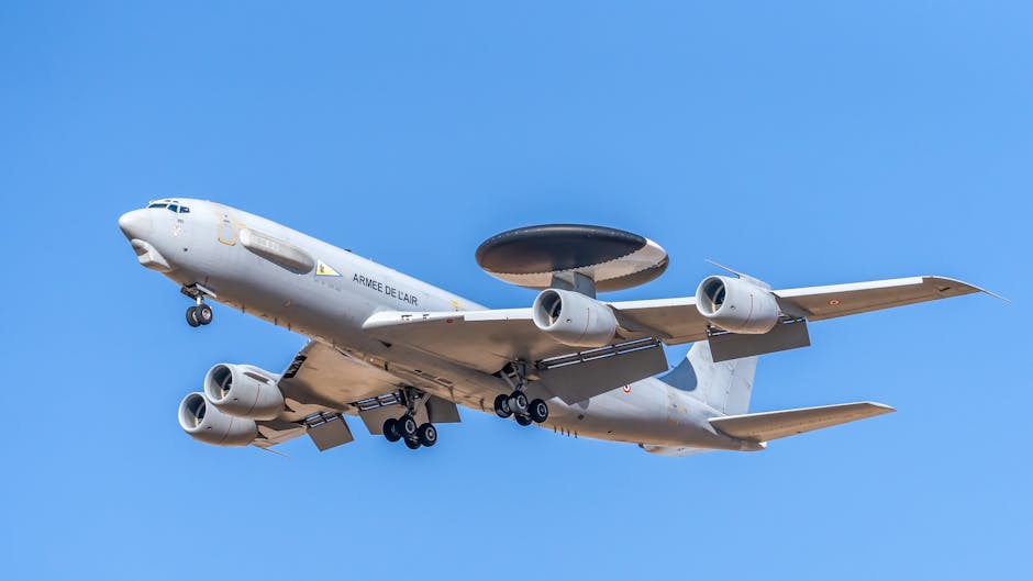 A military AWACS aircraft flying against a clear blue sky, showcasing aerial surveillance capabilities.