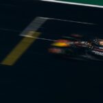 Blurred image of a Formula One car racing down the track, showcasing speed and motion.