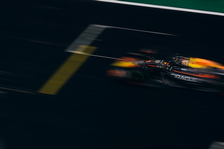 Blurred image of a Formula One car racing down the track, showcasing speed and motion.