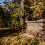 Sarcophagus surrounded by autumn foliage in Warsaw's Wilanow Park.