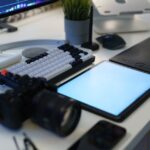 A modern home office with photography equipment, graphic tablet, and ergonomic keyboard.