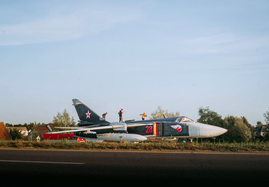 Men explore a Su-24 jet wreckage in a rural field in Belarus.