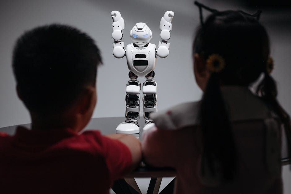 Two children observe a humanoid robot on a table, exploring technology and innovation.