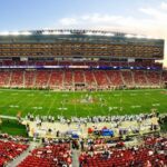 A stunning panoramic shot of Levi's Stadium in Santa Clara during a packed football game at sunset.
