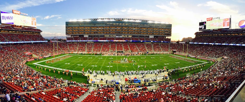 A stunning panoramic shot of Levi's Stadium in Santa Clara during a packed football game at sunset.