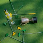 Mini golf setup with colorful putters, a cup, and a flag on green turf. Ideal for casual sports and recreation themes.