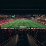 An exciting football match with passionate fans filling the stadium under bright lights, capturing sports energy.