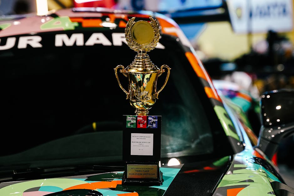 Golden trophy on a vibrant race car hood, symbolizing achievement in motorsports.
