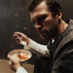 A prisoner in a dark cell eating a simple meal, conveying solitude and introspection.