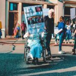 A diverse group of people protesting outdoors with signs and banners in a vibrant street scene.