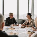 Business professionals engaged in a strategic meeting in a modern office setting with natural light.