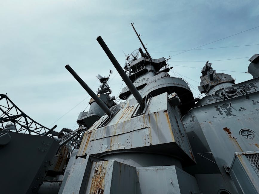 Close-up view of USS Alabama battleship's deck and cannons under a clear sky.