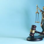 law theme, mallet of the judge and scales of justice on a blue background