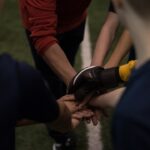 Players putting hands together in unity.