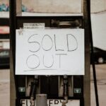 A gas pump at an urban station displaying a 'Sold Out' sign, illustrating fuel shortage.