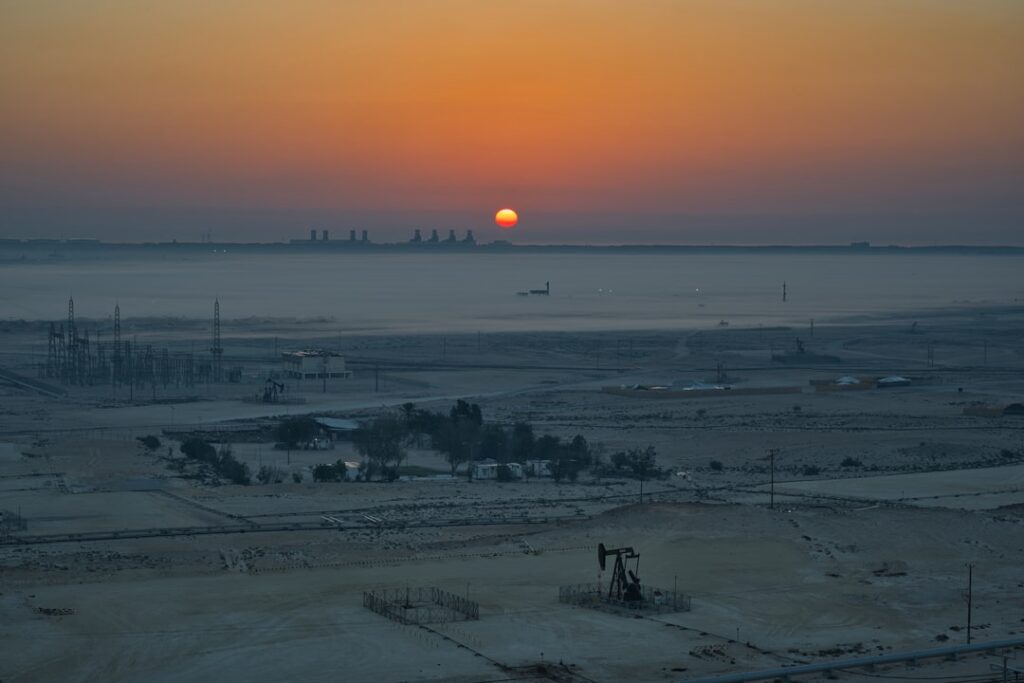 Sunrise over an industrial landscape with oil pumps.