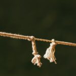 A detailed close-up of a frayed rope against a green blurred background, symbolizing tension.