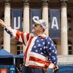 A man in USA patriotic outfit standing in front of building