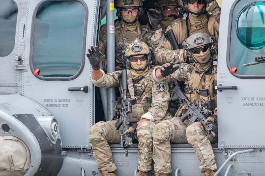Soldiers are sitting in a helicopter doorway.