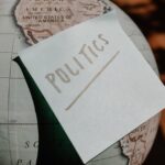 A close-up of a globe with a politics sticky note, symbolizing global political themes.