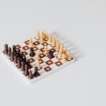A minimalist miniature chess set arrangement on a white background, ideal for strategy concepts.