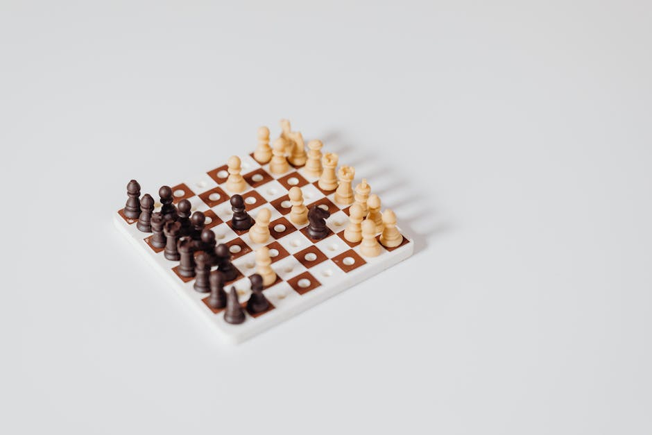 A minimalist miniature chess set arrangement on a white background, ideal for strategy concepts.