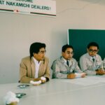 Four men sit at a table during a meeting.