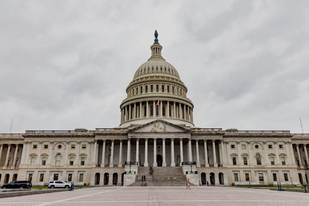 The united states capitol building stands under a cloudy sky.