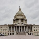 The united states capitol building stands under a cloudy sky.