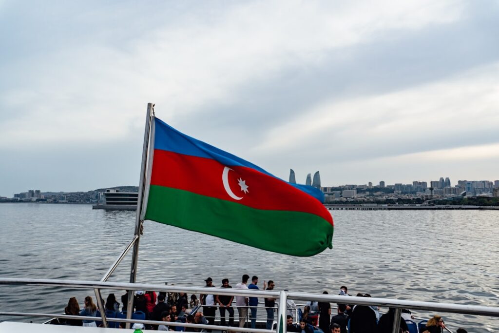The azerbaijani flag waves above the water.